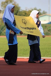 Volunteers carrying special olympics banner